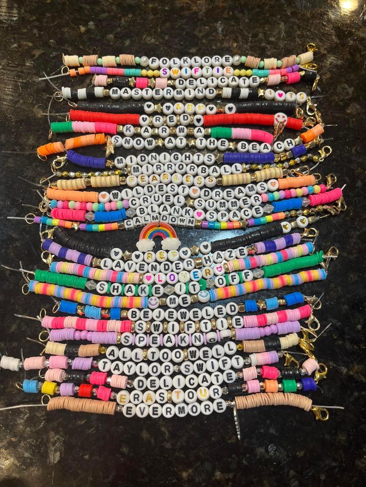 a bunch of different colored beads are on a table with some string attached to it