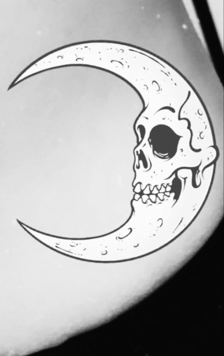 a black and white photo of a crescent moon with a skull on it