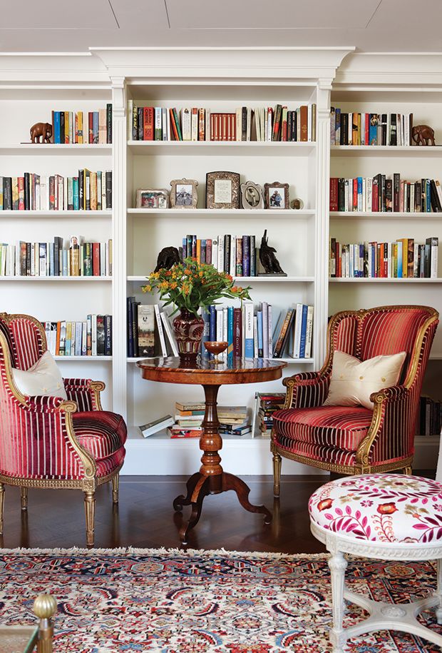 two chairs and a table in front of bookshelves