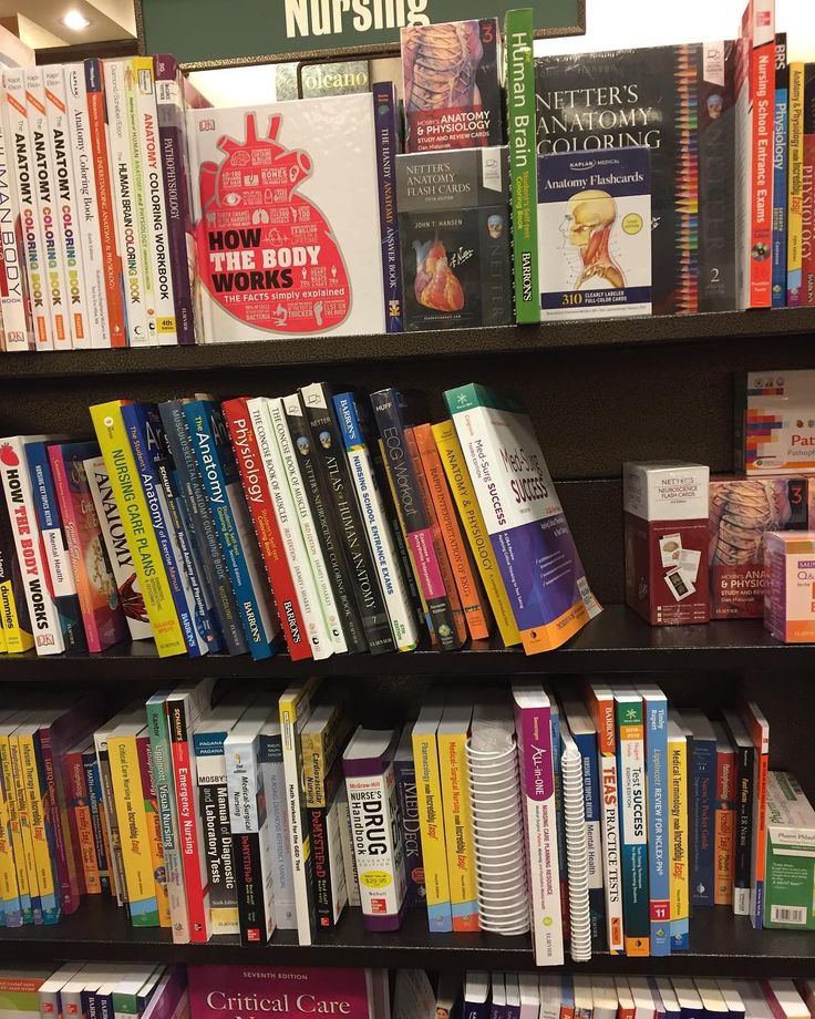 a bookshelf filled with lots of different colored books and papers on top of each shelf