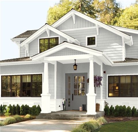 a blue house with white trim on the front door and porch is pictured in this image