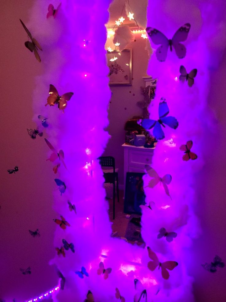 a room with purple lights and butterflies on the walls, in front of a mirror