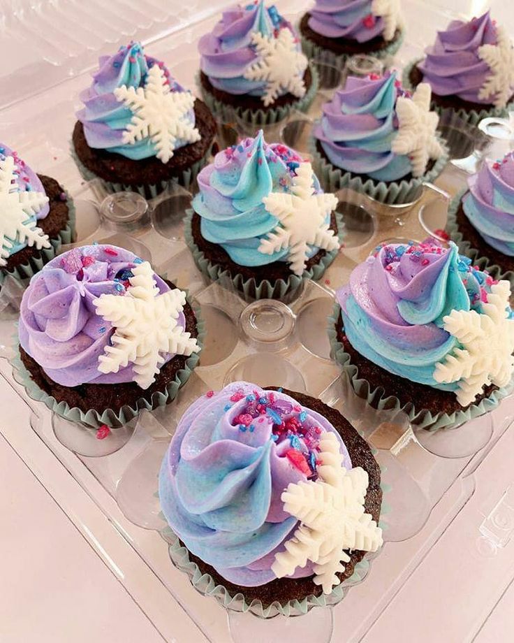 cupcakes decorated with frosting and sprinkles on a clear tray