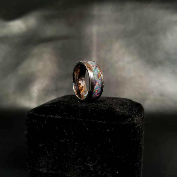 "Titanium Core Ring with OP 78 Blue Gray Opal inlaid into the central channel. May be used as an engagement ring, a promise ring, or wedding ring, or can be used as a beautiful piece of jewelry to adorn a special hand. The Synthetic, Crushed Peacock Opal has a wonderful \"color-of-play\" that will dazzle in any form of lighting. The color of opal, Peacock, has a unique blend of teal, blue, and green in it. Titanium core ring to be chosen for the wearer in either 6 mm or 8 mm sizes. This specific Silver Titanium Promise Ring, Titanium Silver Ring Jewelry, Titanium Promise Ring, Silver Titanium Ring, Elegant Titanium Ring, Elegant Titanium Ring Jewelry, Silver Titanium Promise Jewelry, Titanium Ring For Anniversary, Formal Titanium Ring Jewelry