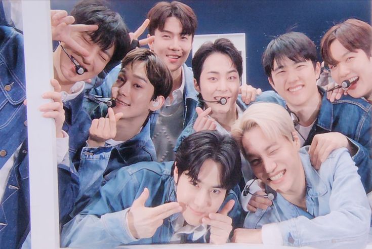 a group of young men standing next to each other in front of a sign that says japan love