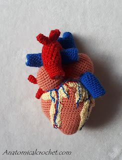 a crocheted heart is shown in red, white and blue yarn with an attached brooch