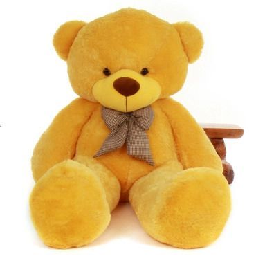 a large yellow teddy bear sitting on top of a wooden bench with a bow tie around its neck