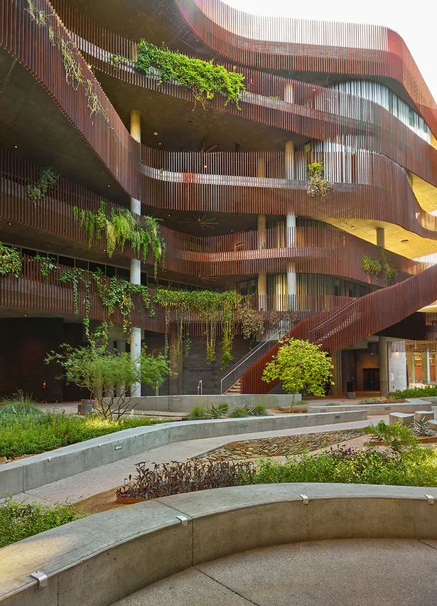 a building with many balconies and plants growing on the side of it's sides