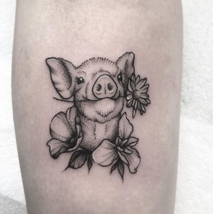 a small pig with flowers on it's leg