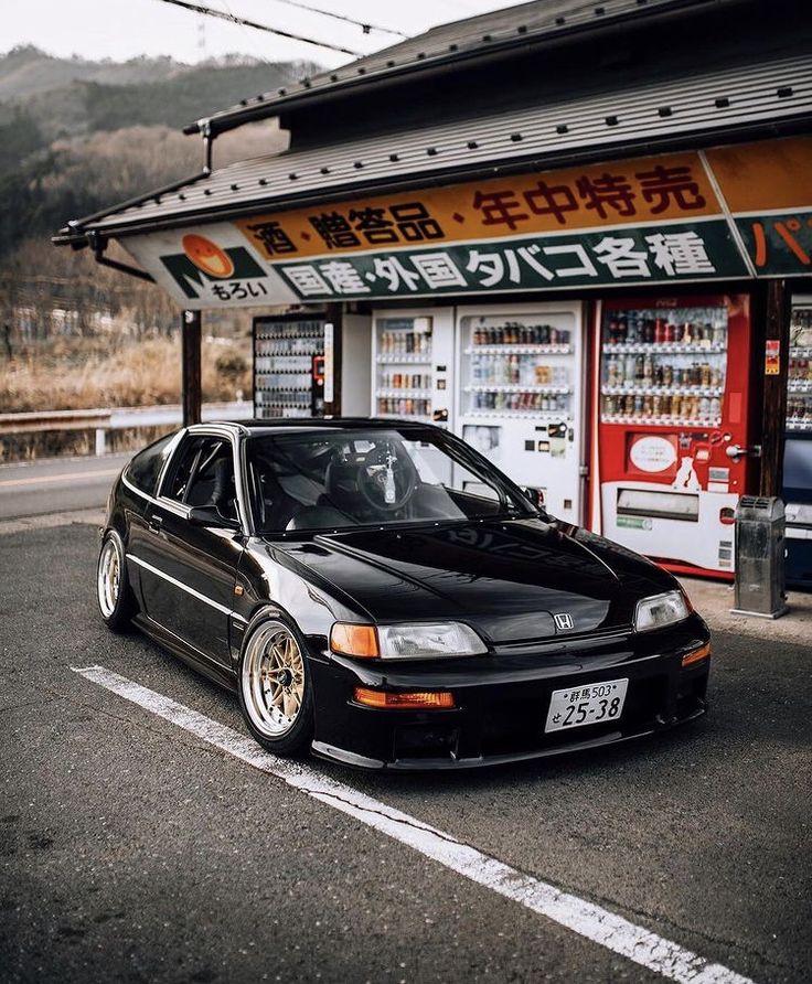 a black car parked in front of a store