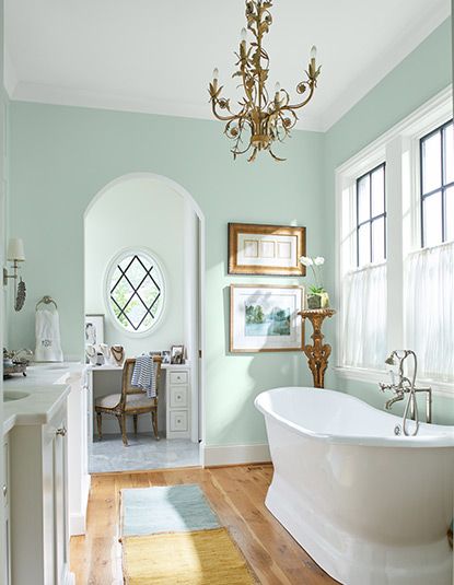 a white bath tub sitting in a bathroom next to a window