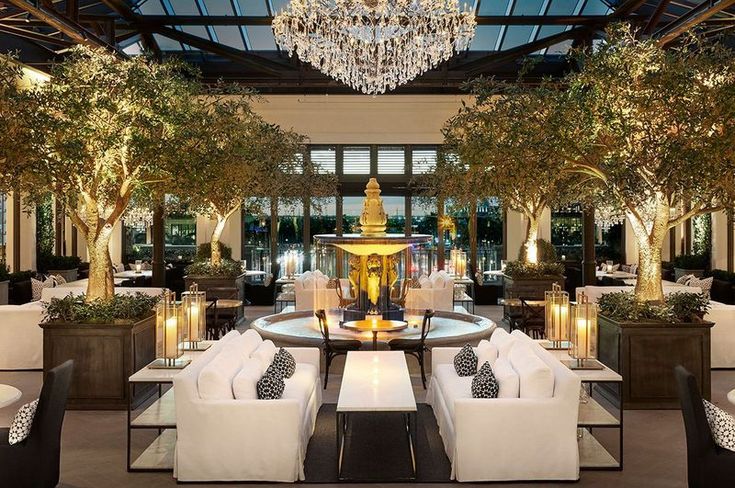 the interior of a restaurant with chandelier hanging from the ceiling and white couches