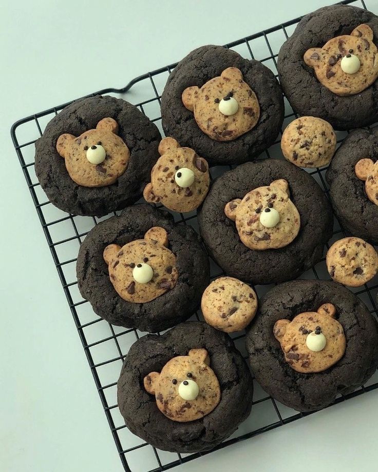 chocolate chip cookies with teddy bears in the middle are cooling on a wire rack, ready to be eaten