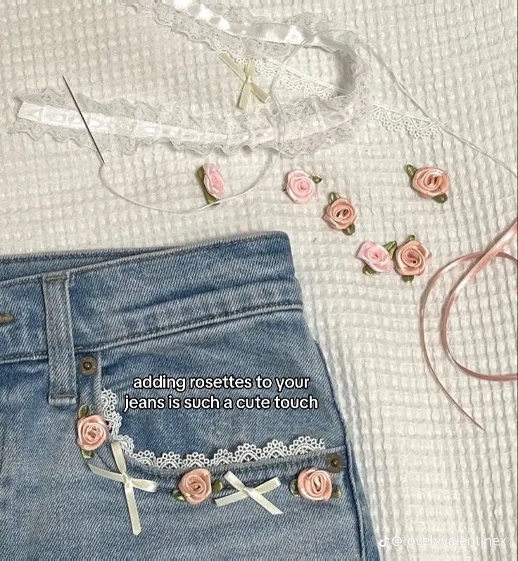 a pair of jeans with pink roses on them next to a white lace bralet