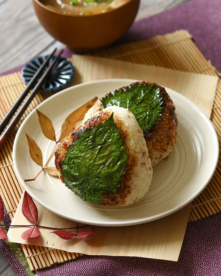 two pieces of food on a plate with chopsticks