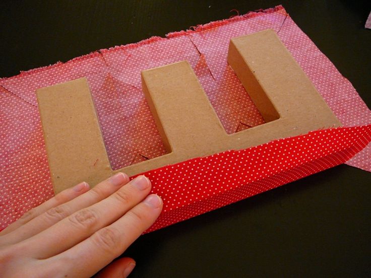 someone is cutting out the letters from cardboard and wrapping them in red polka dot paper