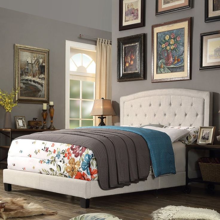 a bedroom with gray walls and pictures on the wall, including a white bed frame