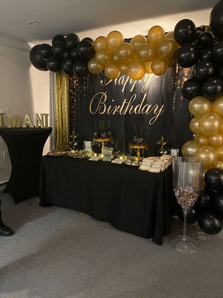 a birthday party with black and gold balloons