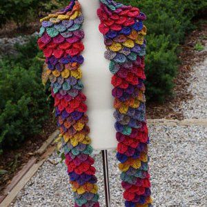 a white mannequin with a multicolored crochet scarf on it