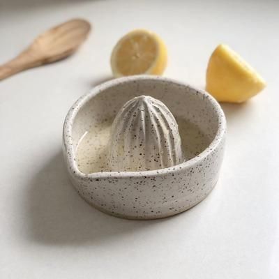 a small bowl with some fruit in it on a table next to a wooden spoon