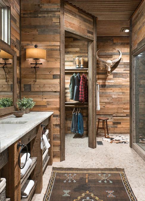 a bathroom with wooden walls and a rug on the floor