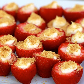 strawberries with cream and sprinkles are arranged on a white platter