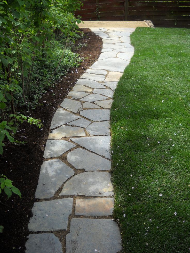 a stone path in the middle of a garden