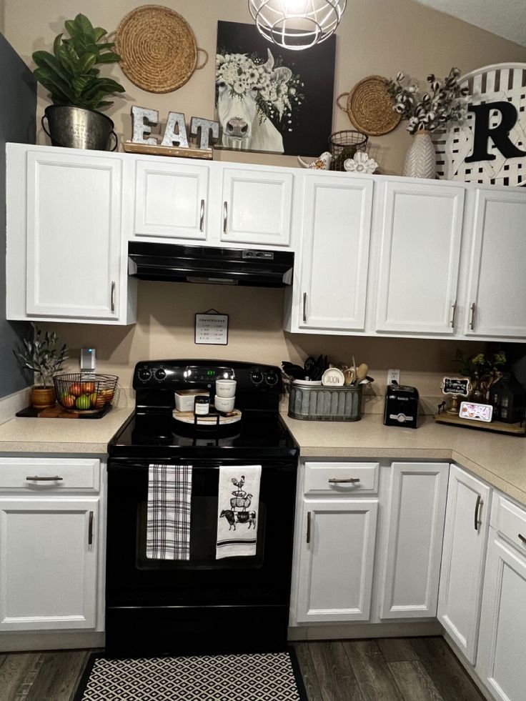 a kitchen with white cabinets and black appliances