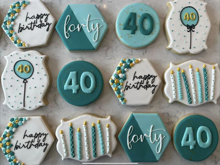 decorated cookies are arranged on a white wooden surface, with candles and happy birthday messages