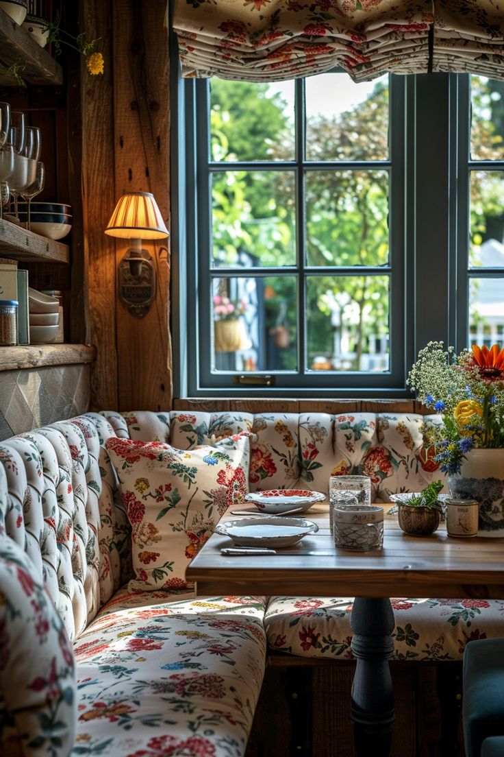 a table with flowers on it in front of a window