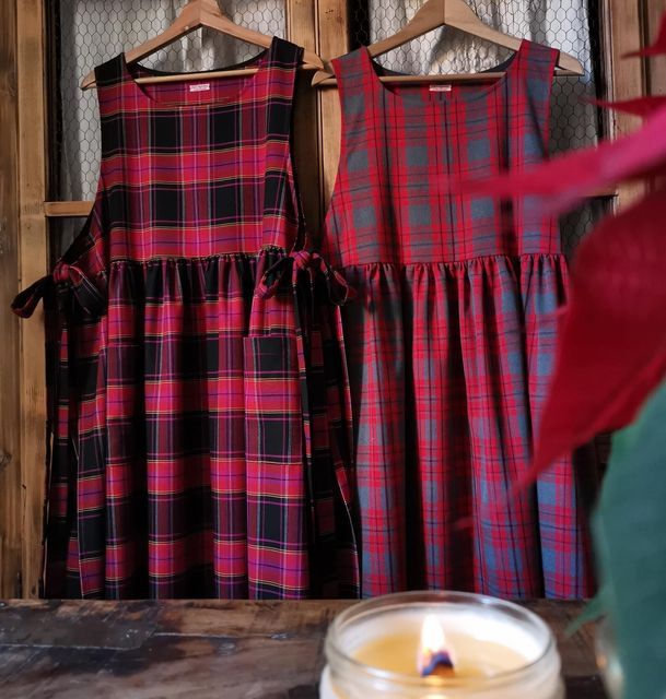 two dresses are hanging next to a candle