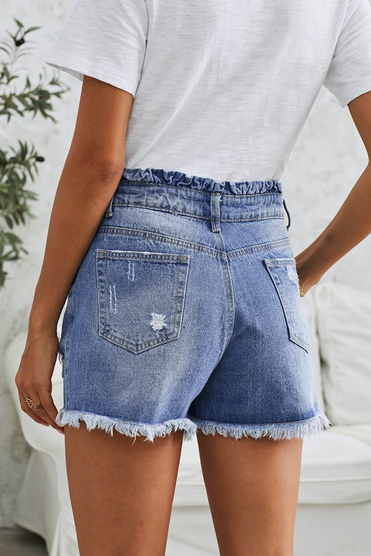 Shorts fit with a high rise, relaxed fit, and no stretch fabrication, medium wash with subtle fading and whiskering. A soft ruffled waistband completes the look. Sizes: Small 0-4 Medium 6-8 Large 10-12 X Large 14-16 Model is 5'6'' wearing size small. Length of small approx. 15''. 100% Cotton Relaxed Fit High Waist Bottoms With Frayed Hem, Spring Paperbag Waist Bottoms With Relaxed Fit, Trendy Paperbag Waist Bottoms With Relaxed Fit, Casual Blue Ruffled Bottoms, Casual High-waisted Shorts With Frayed Hem, Casual Dark Wash Ruffled Bottoms, Spring Dark Wash Ruffled Bottoms, Spring Ruffled Dark Wash Bottoms, High Waist Ruffled Denim Blue Bottoms