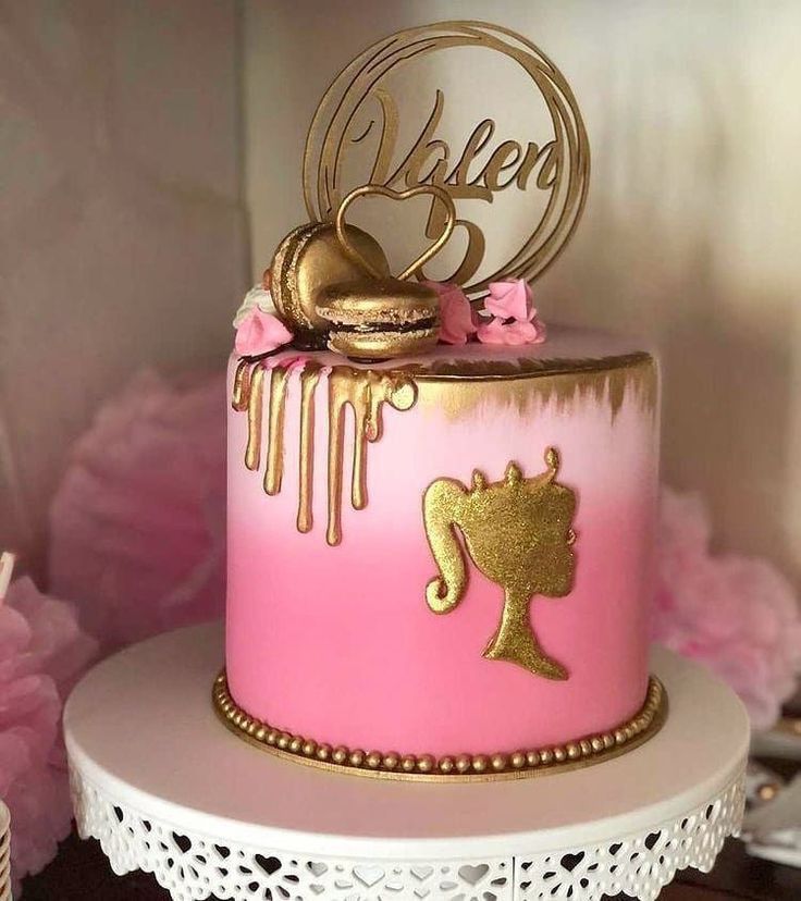 a pink cake with gold decorations on top