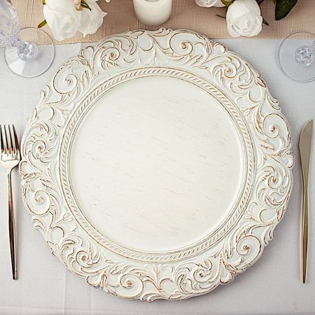 a table setting with white flowers and silverware