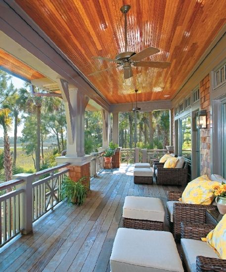 an outdoor covered porch with wicker furniture