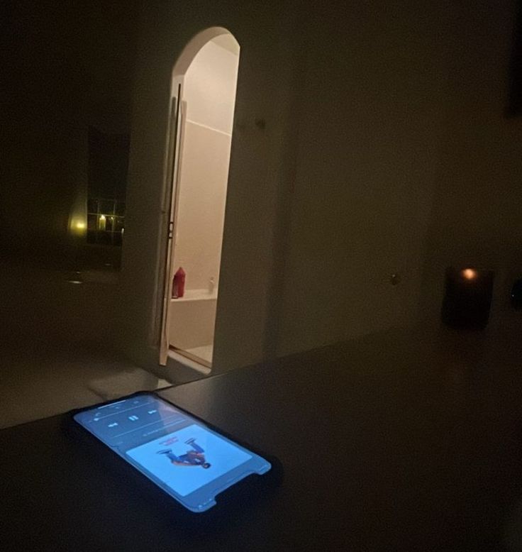 an electronic device sitting on top of a table in front of a doorway at night