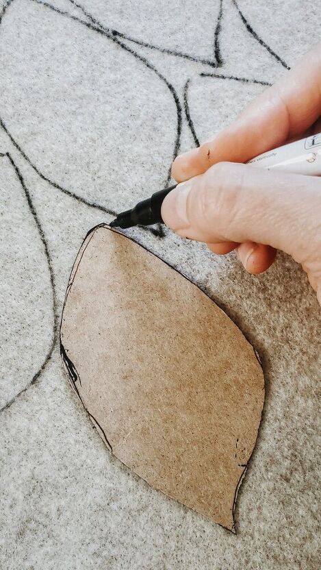 someone using scissors to cut the fabric off of a piece of cloth on top of a rug