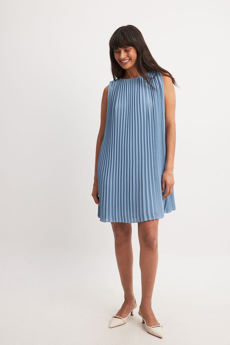 This mini dress features a flowy fit and a plissé style. It has a round neck and a sleeveless design. Our mini dress has a loop closure behind the neck. Spring Sleeveless Mini Dress With Pleated Hem, Sleeveless Summer Mini Dress With Pleated Back, Sleeveless Summer Mini Dress With Pleated Hem, Summer Sleeveless Mini Dress With Pleated Hem, Sleeveless Mini Dress With Pleated Back For Summer, Sleeveless Mini Dress With Pleated Hem For Spring, Summer Mini Dress With Pleated Hem, Sleeveless Spring Mini Dress With Pleated Bodice, Sleeveless Mini Dress With Pleated Bodice For Spring