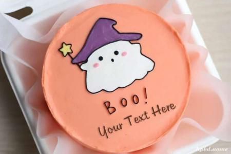 a decorated cookie with an image of a ghost in a purple witches hat on it