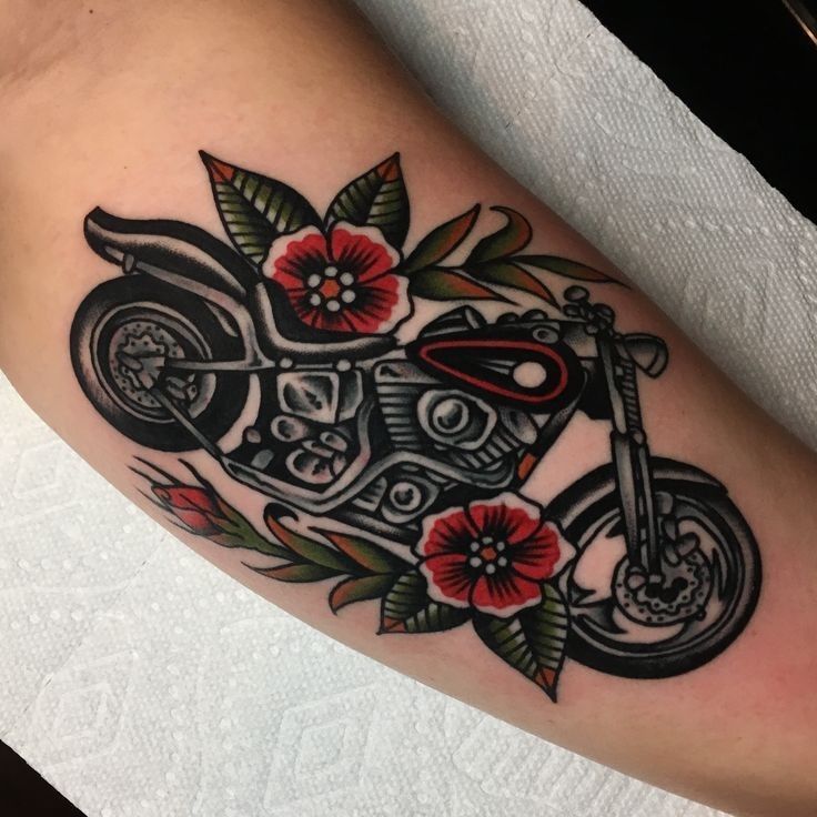 a tattoo on the leg of a person with a motorcycle and flowers in it's frame