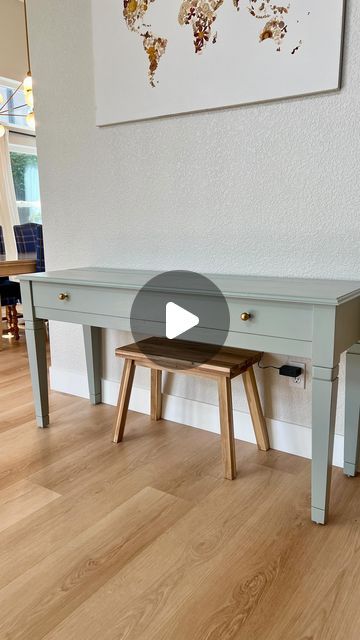 a table with two stools in front of it and a map on the wall