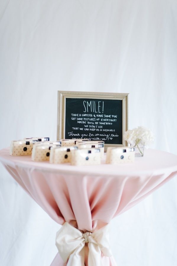 a table topped with candles and a small chalkboard on top of it's stand