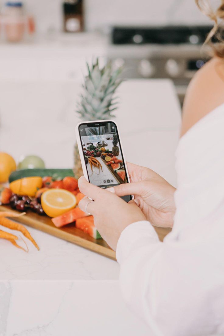 a woman taking a photo of food on her phone