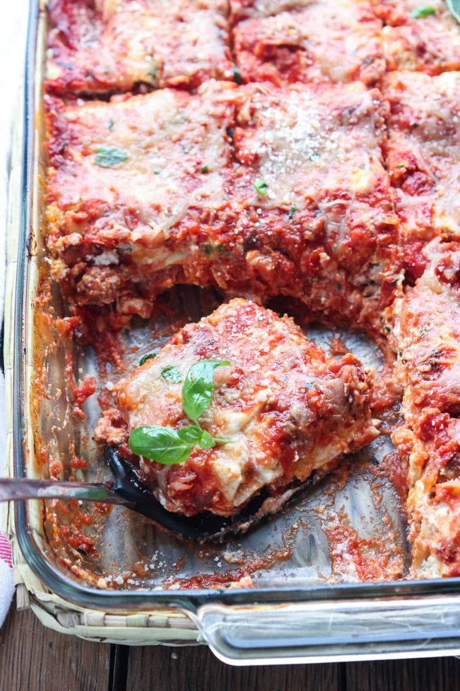 lasagna casserole in a glass dish with a serving spoon on the side