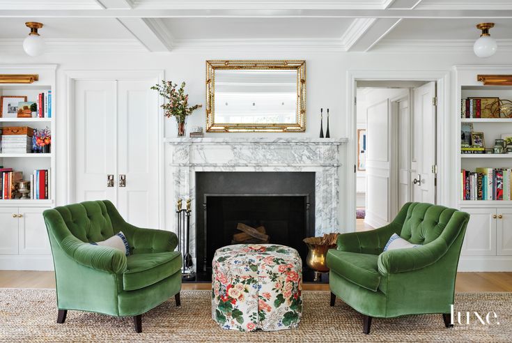 two green chairs sitting in front of a fireplace