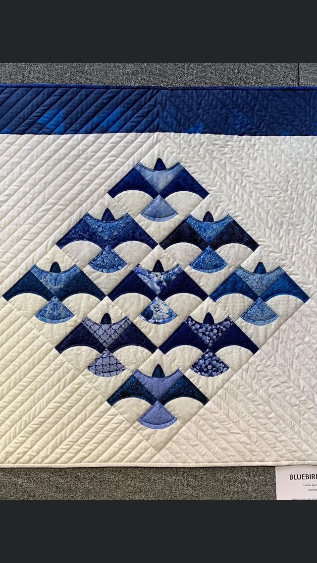 a blue and white quilt on display in a room