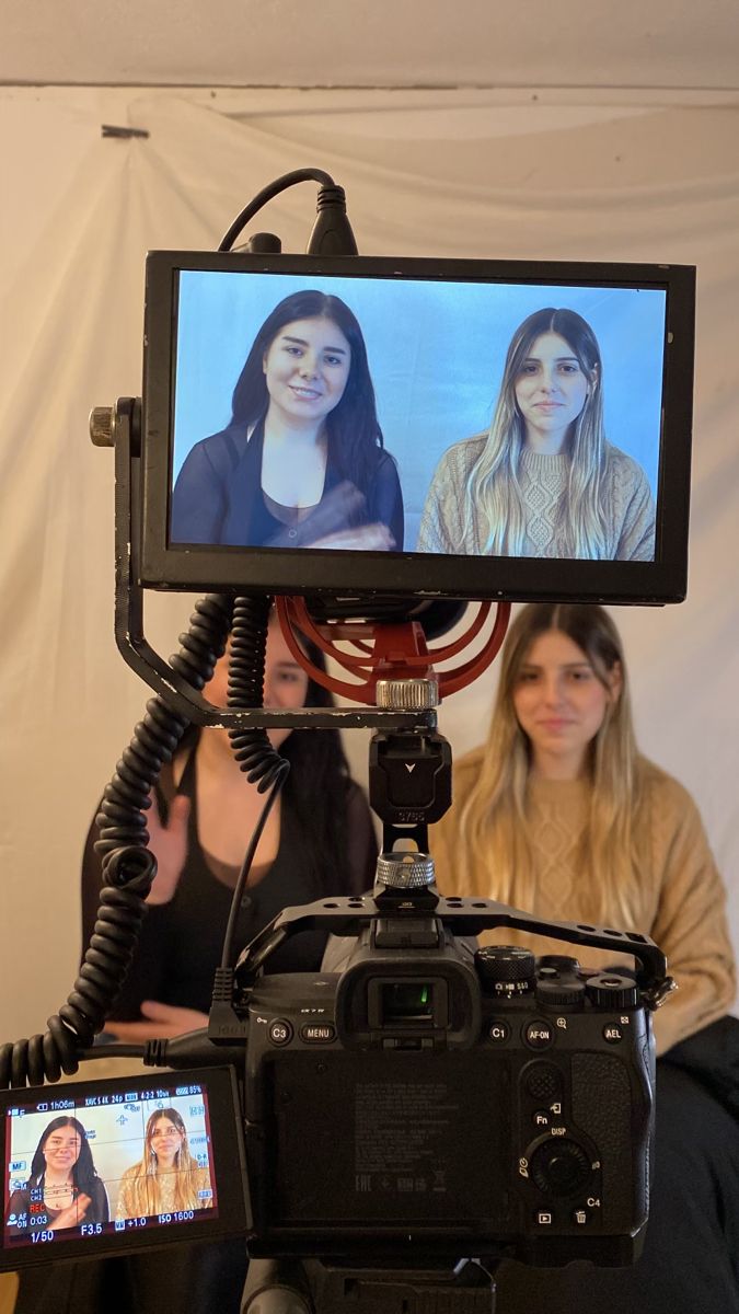 two women sitting in front of a camera