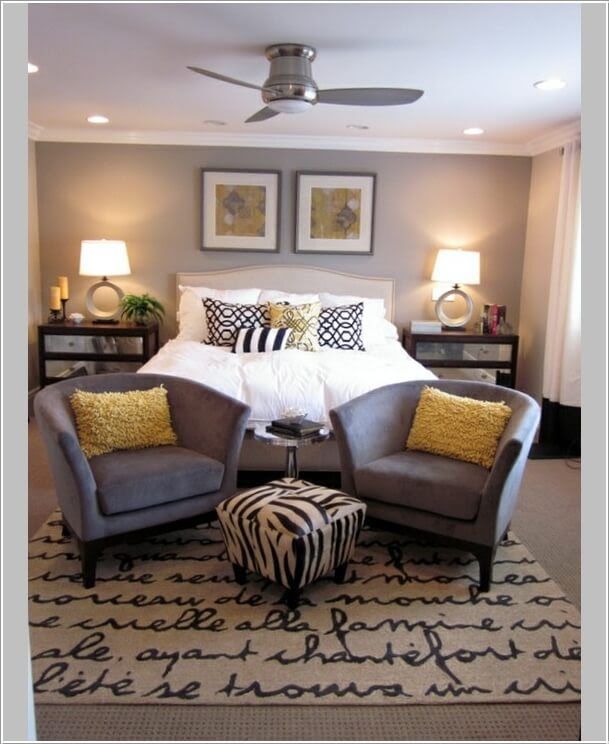 a bed room with a neatly made bed and two zebra print ottomans on the floor