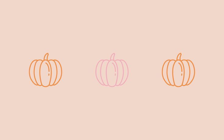 three pumpkins in different colors on a pink background