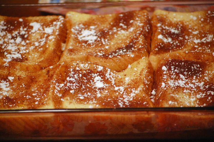 powdered sugar on top of french toast in a baking dish, ready to be eaten